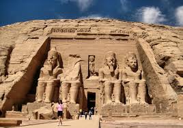 A group of people walking in front of a stone building with Abu Simbel temples in the background

Description automatically generated